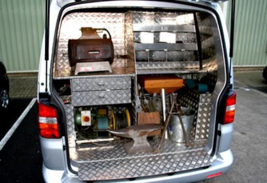 Aménagement d'un utilitaire de maréchal-ferrant avec enclume et forge.